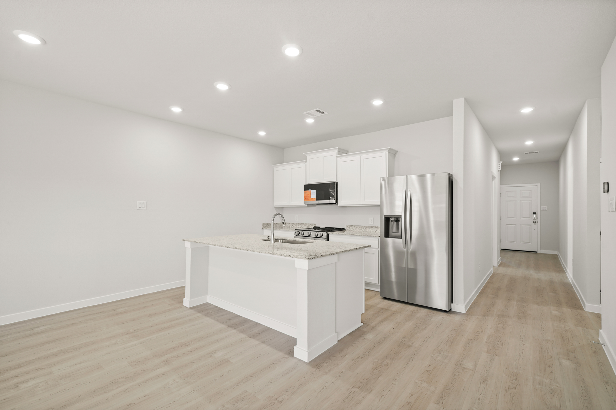 A kitchen with white cabinets.