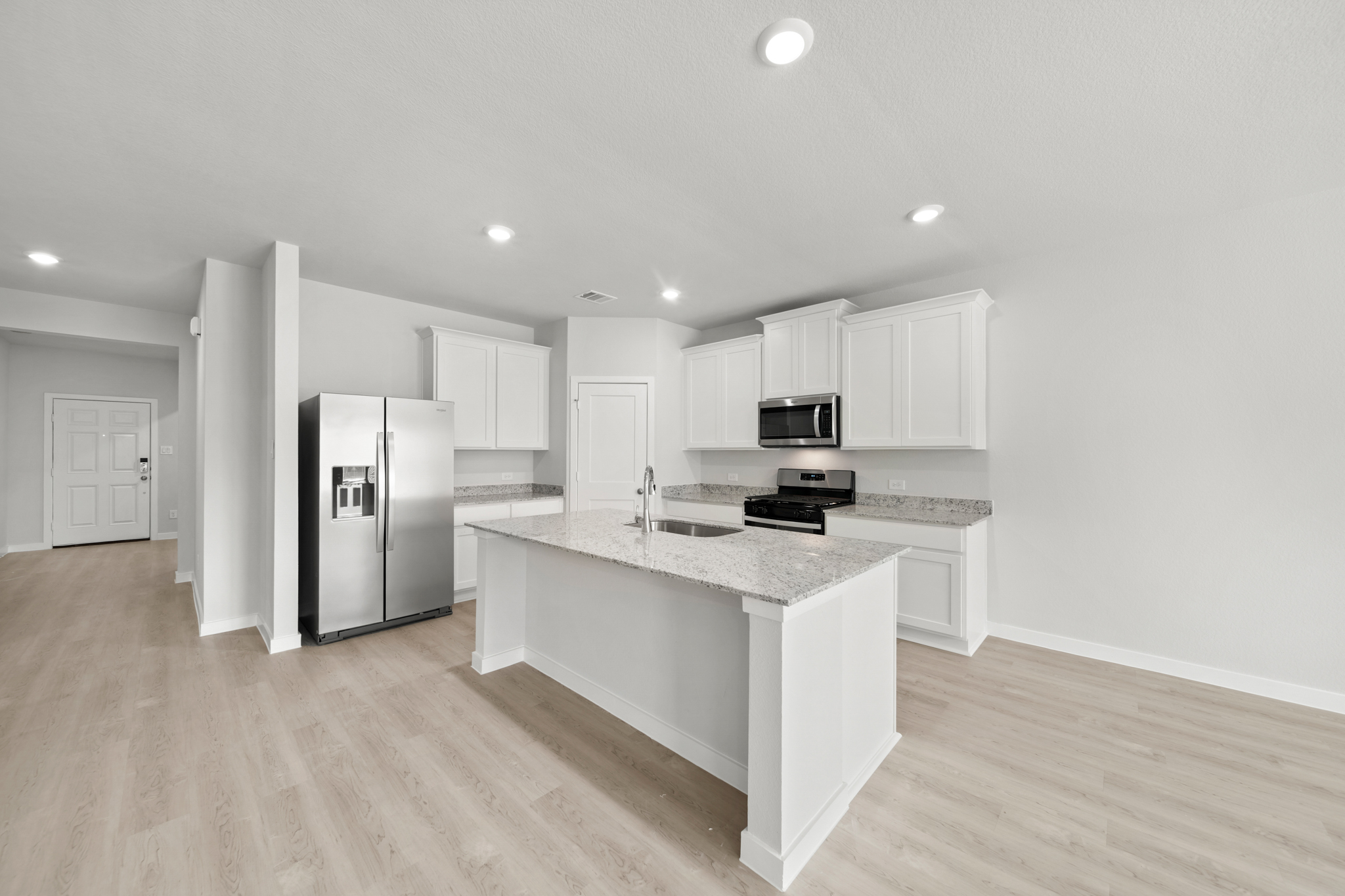 A kitchen with white cabinets.