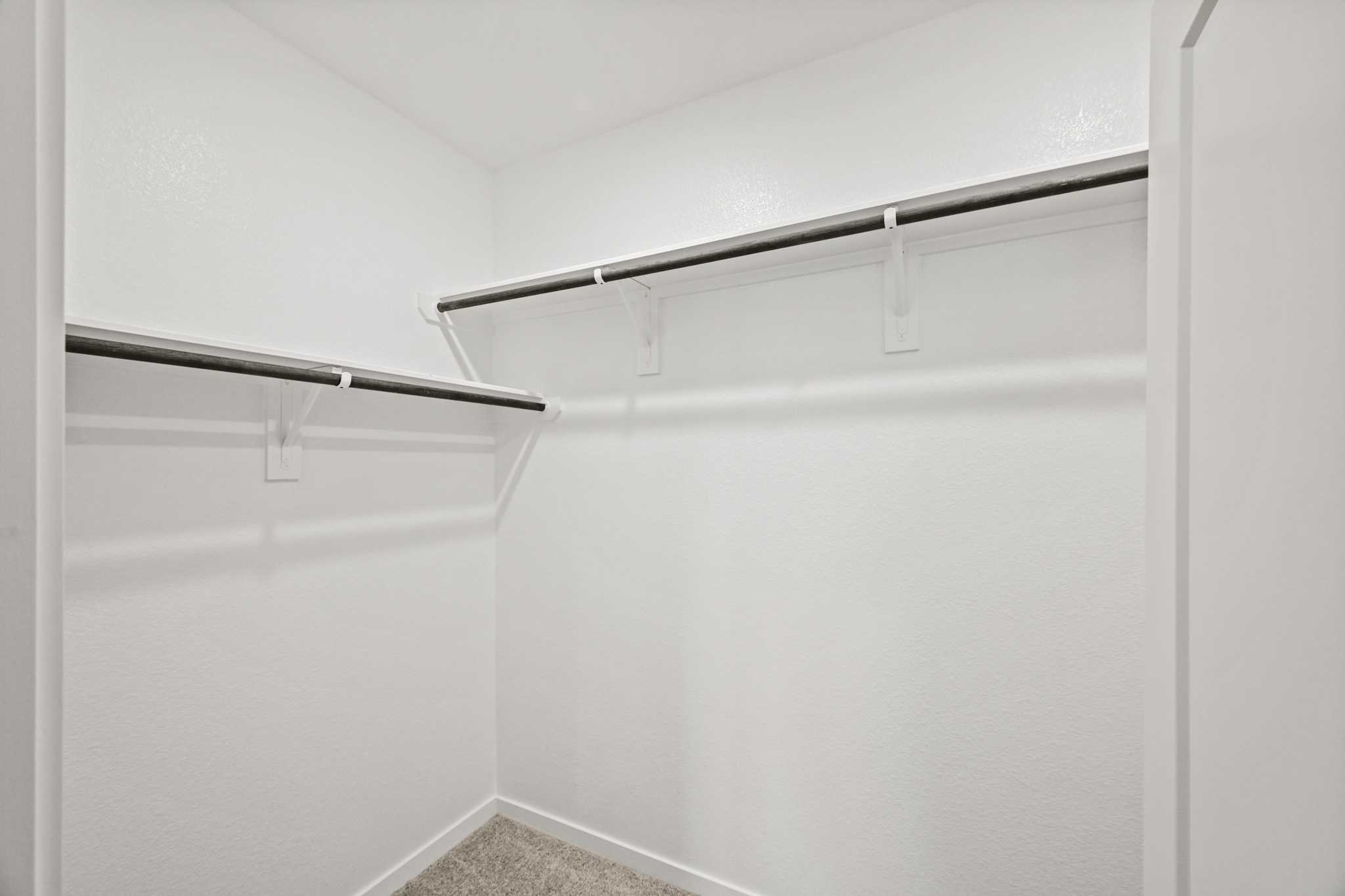 A white wall with a metal bar.