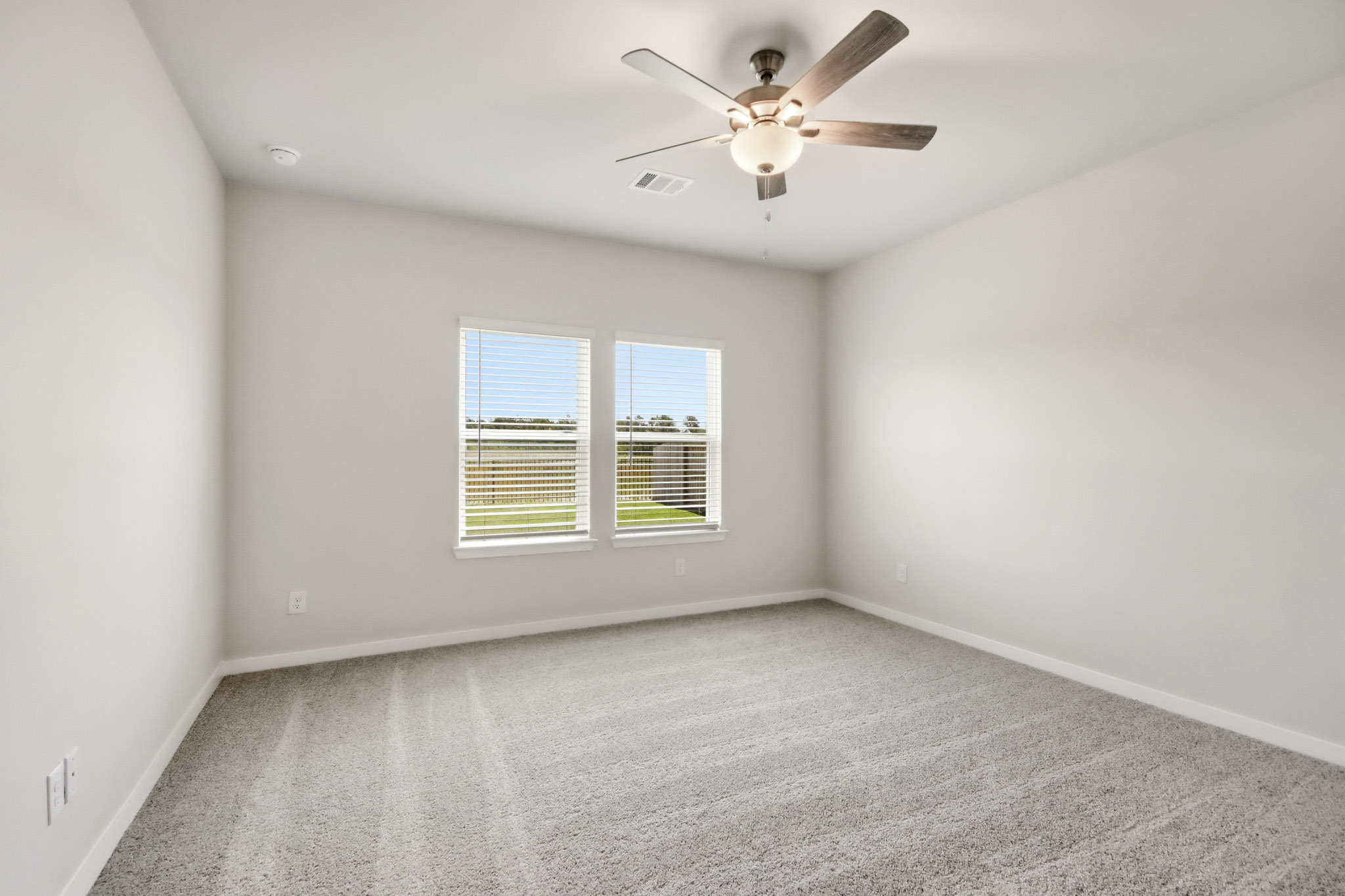 A room with a ceiling fan and a window.