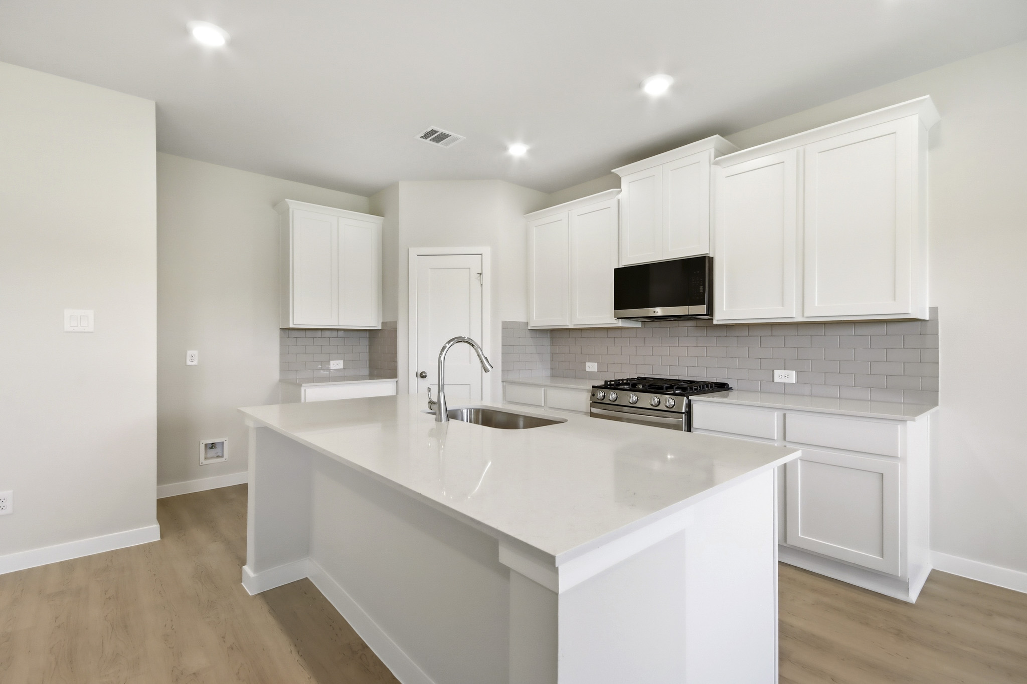 A kitchen with white cabinets.