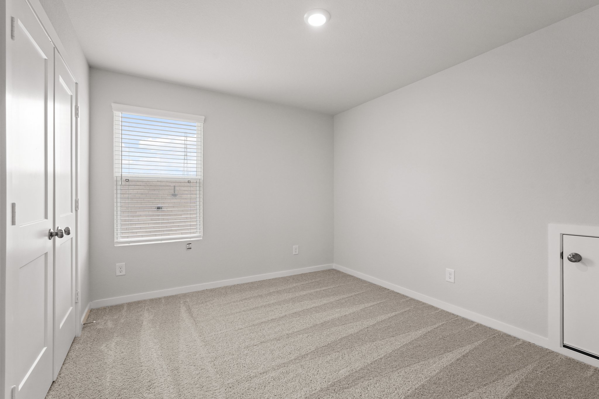 A room with a carpet and a window.