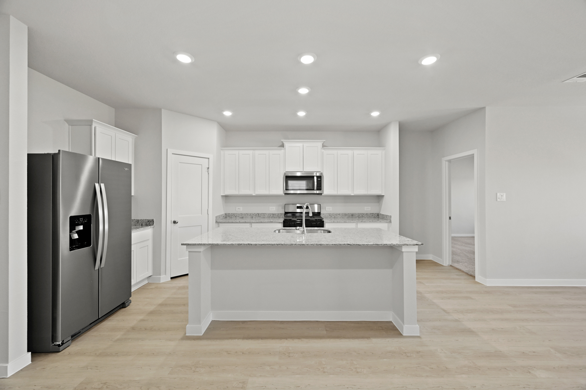A kitchen with white cabinets.