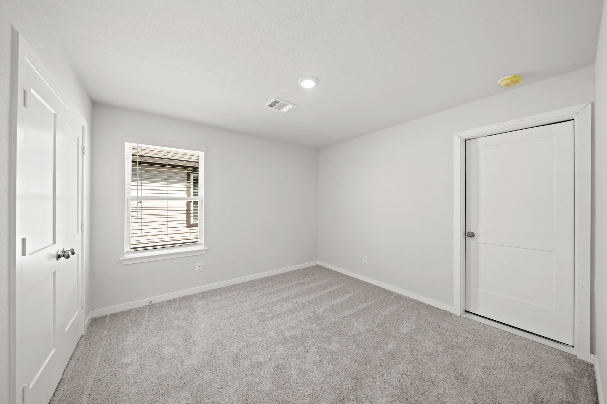 A room with white walls and a window.