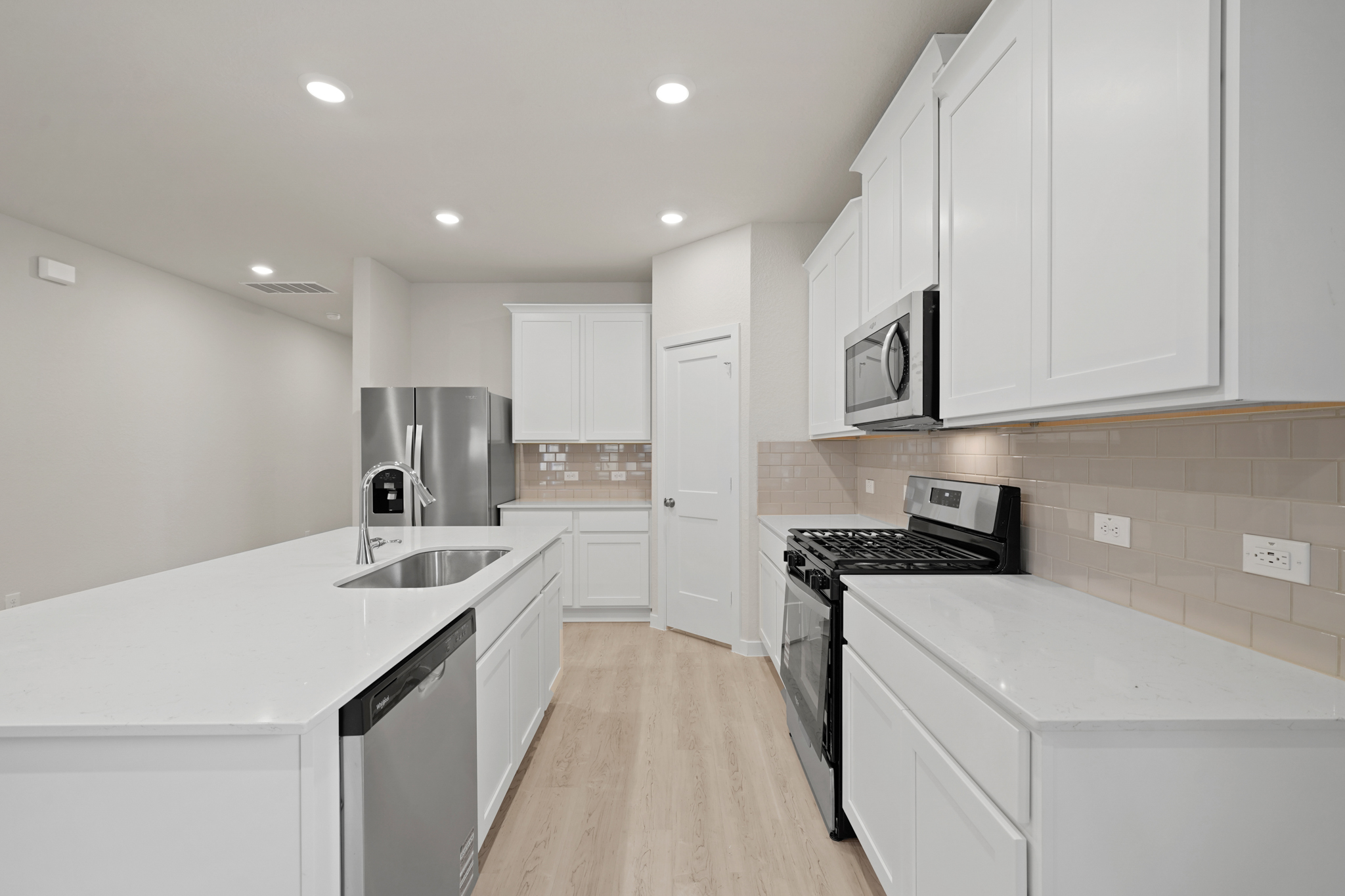 A kitchen with white cabinets.