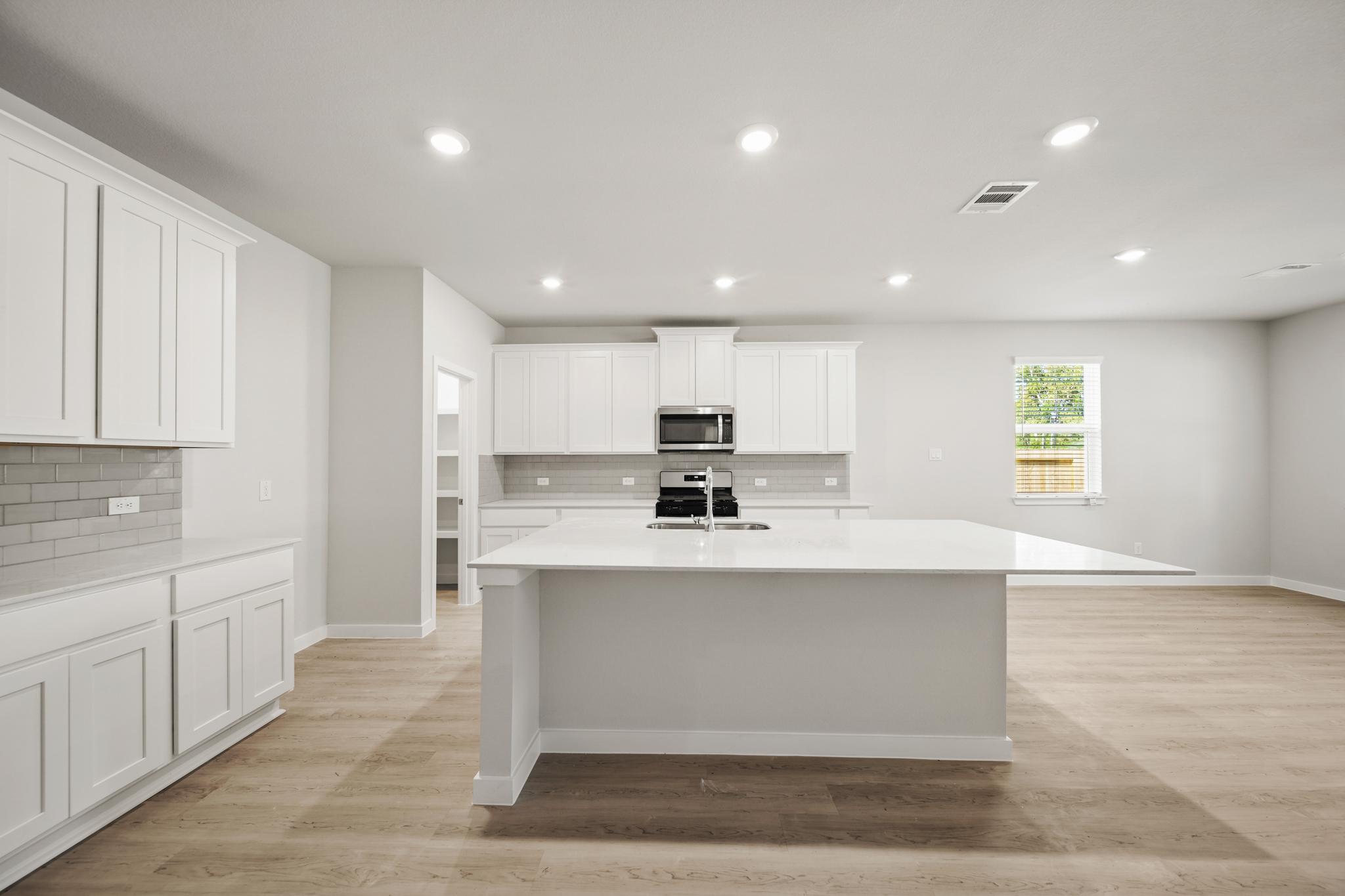 A kitchen with white cabinets.