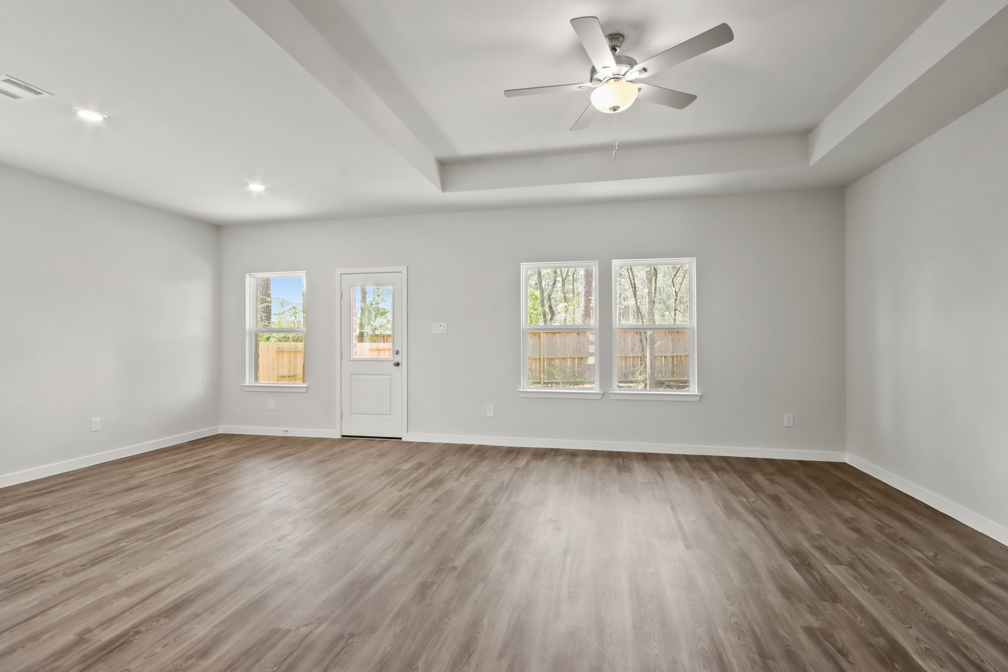 A room with a wood floor and a ceiling fan.