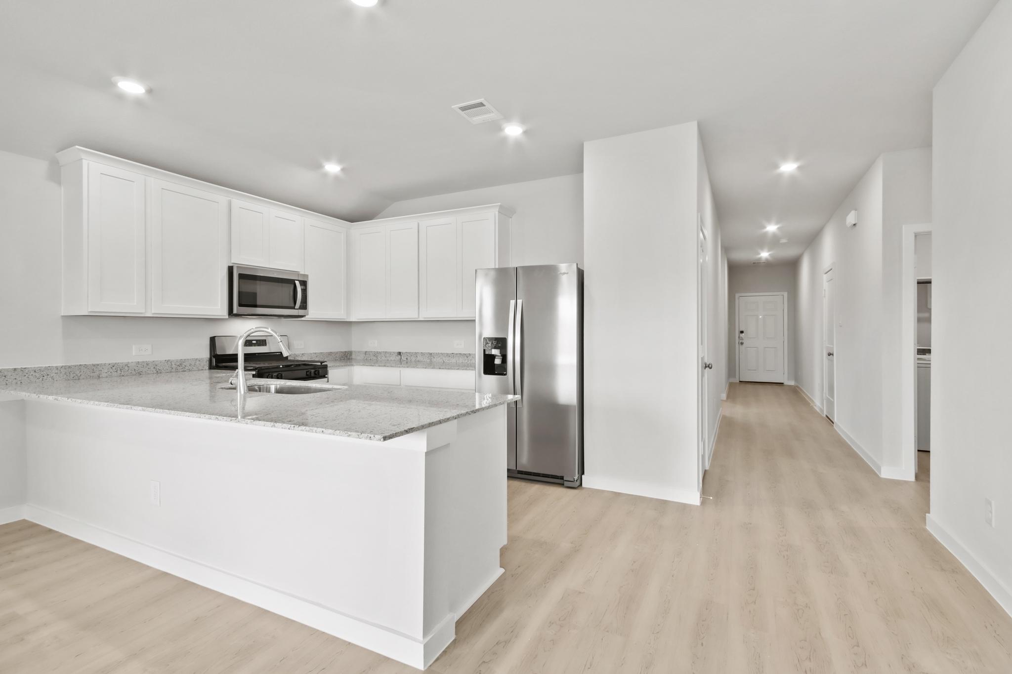 A kitchen with white cabinets.