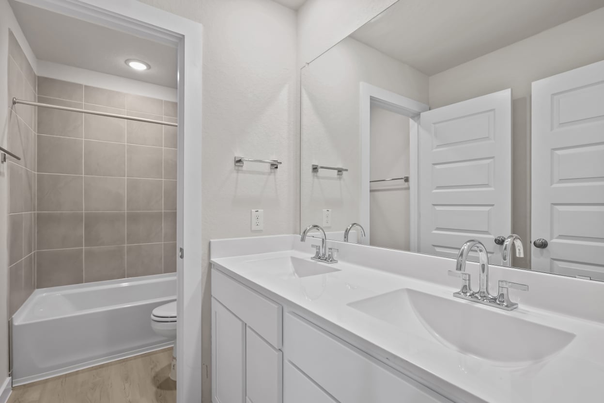 A bathroom with a tub sink and a toilet.