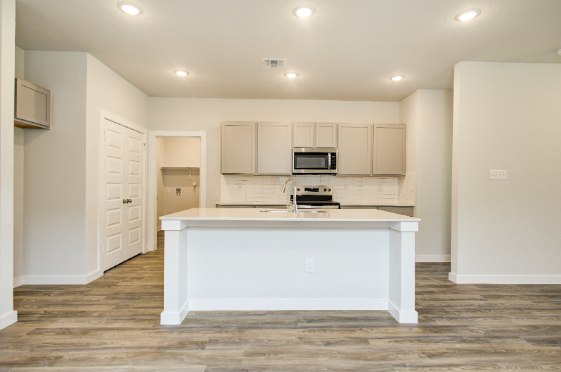 A kitchen with white cabinets.