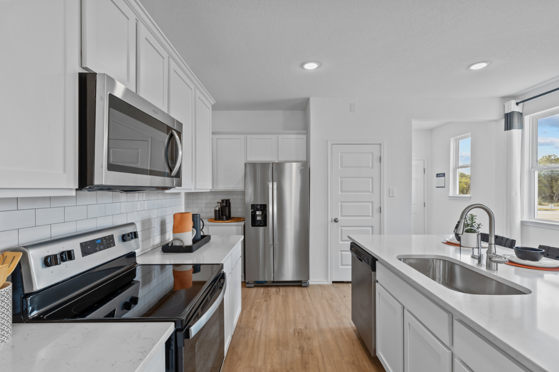 A kitchen with white cabinets.