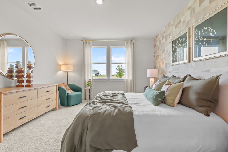 A bedroom with a bed and a mirror.