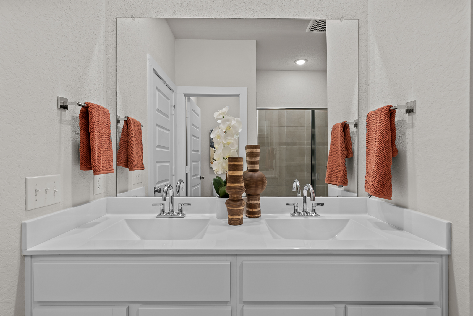 A bathroom with a large mirror.