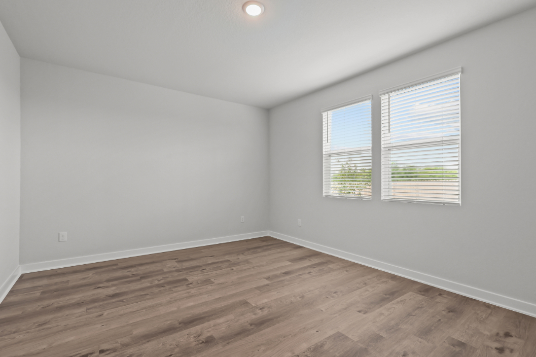 A room with a wood floor and a wood floor with a window.