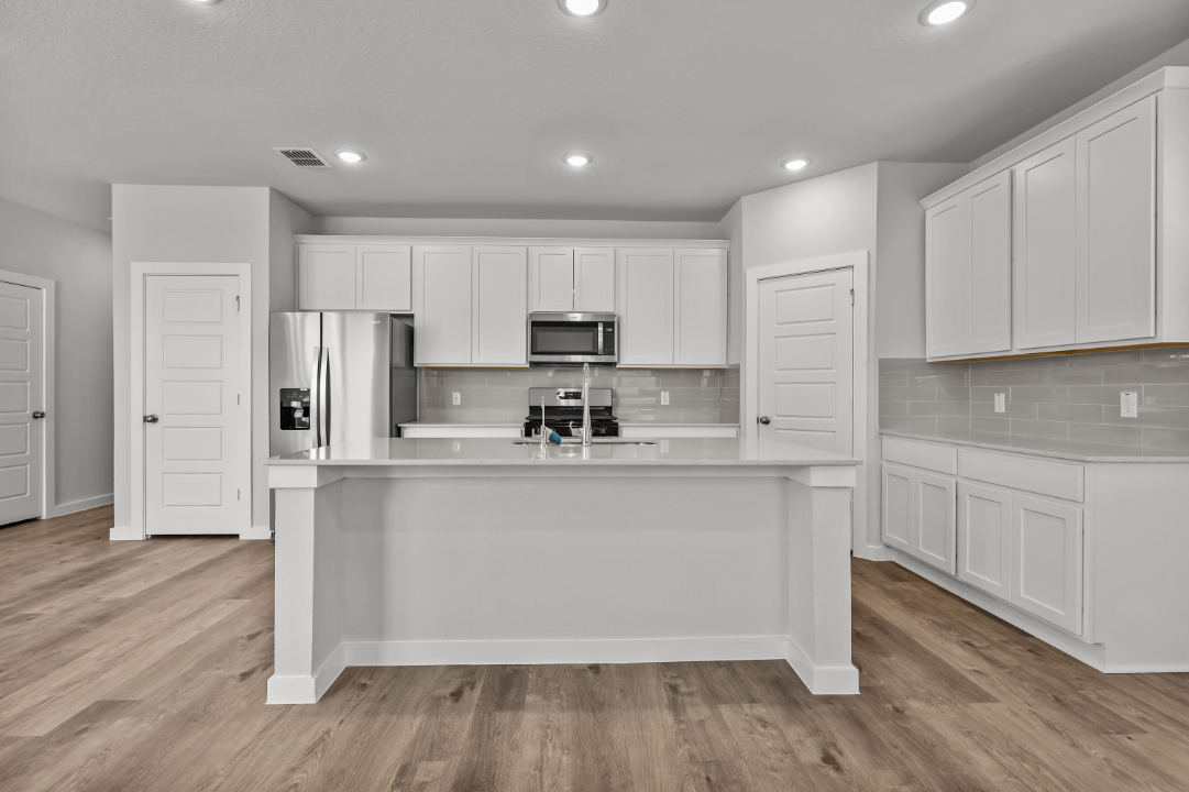 A kitchen with white cabinets.