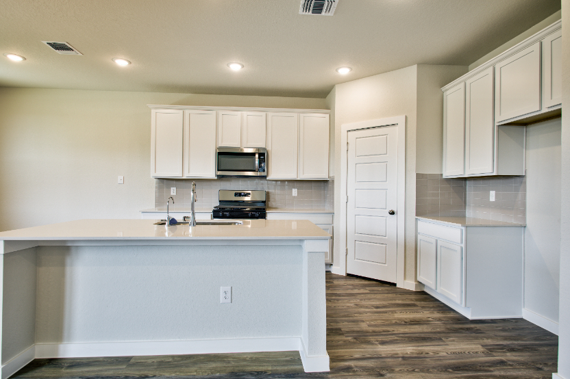 A kitchen with white cabinets.
