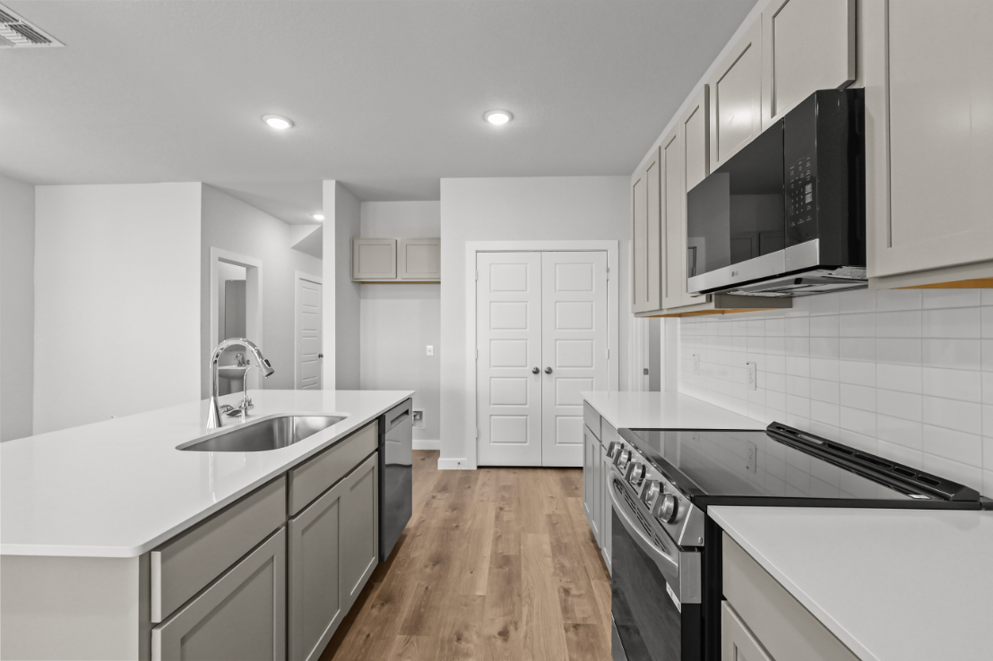 A kitchen with white cabinets.