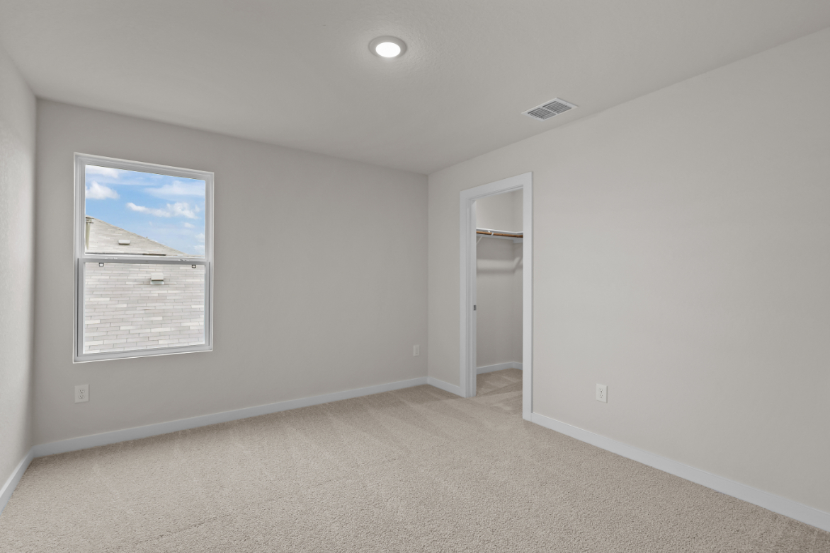 A hallway with a door and a framed picture on the wall.