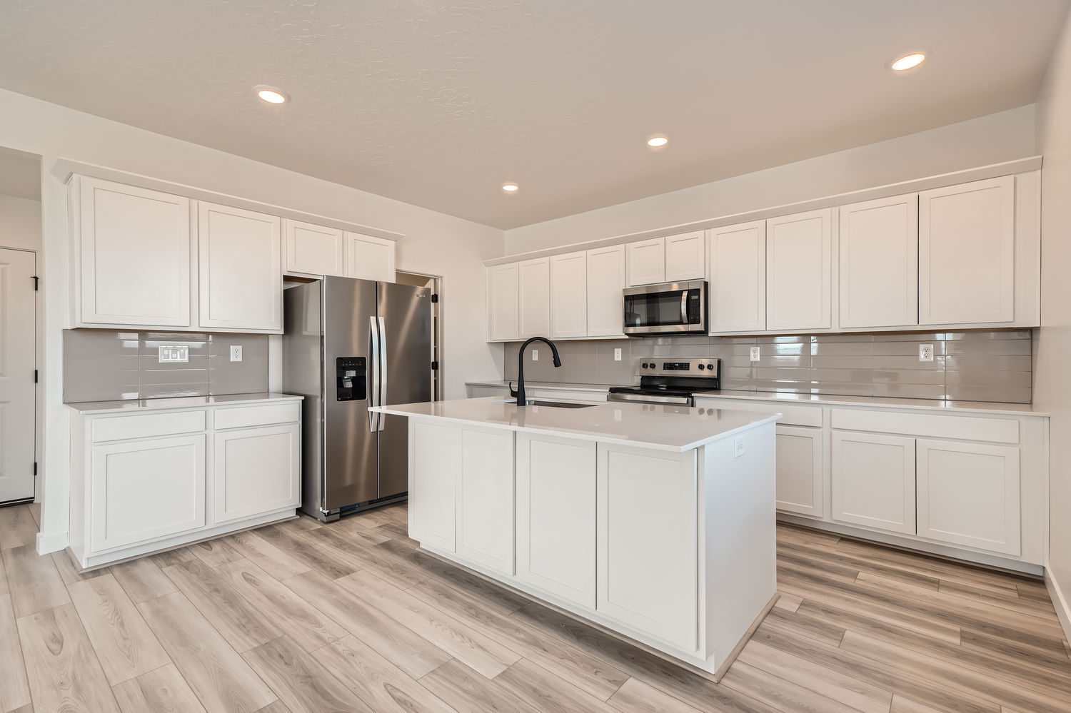 A kitchen with white cabinets.