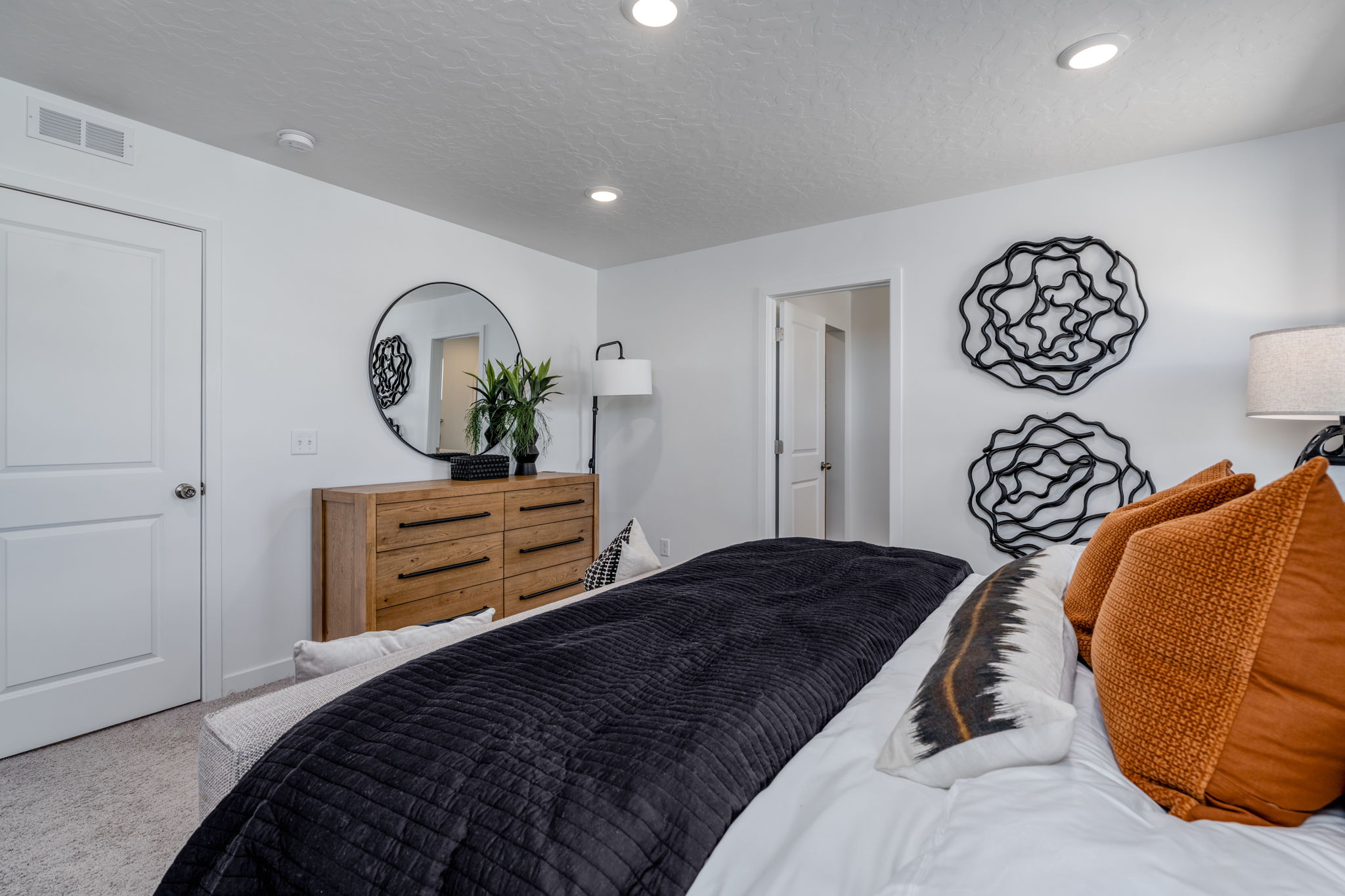 A bedroom with a bed and a mirror.