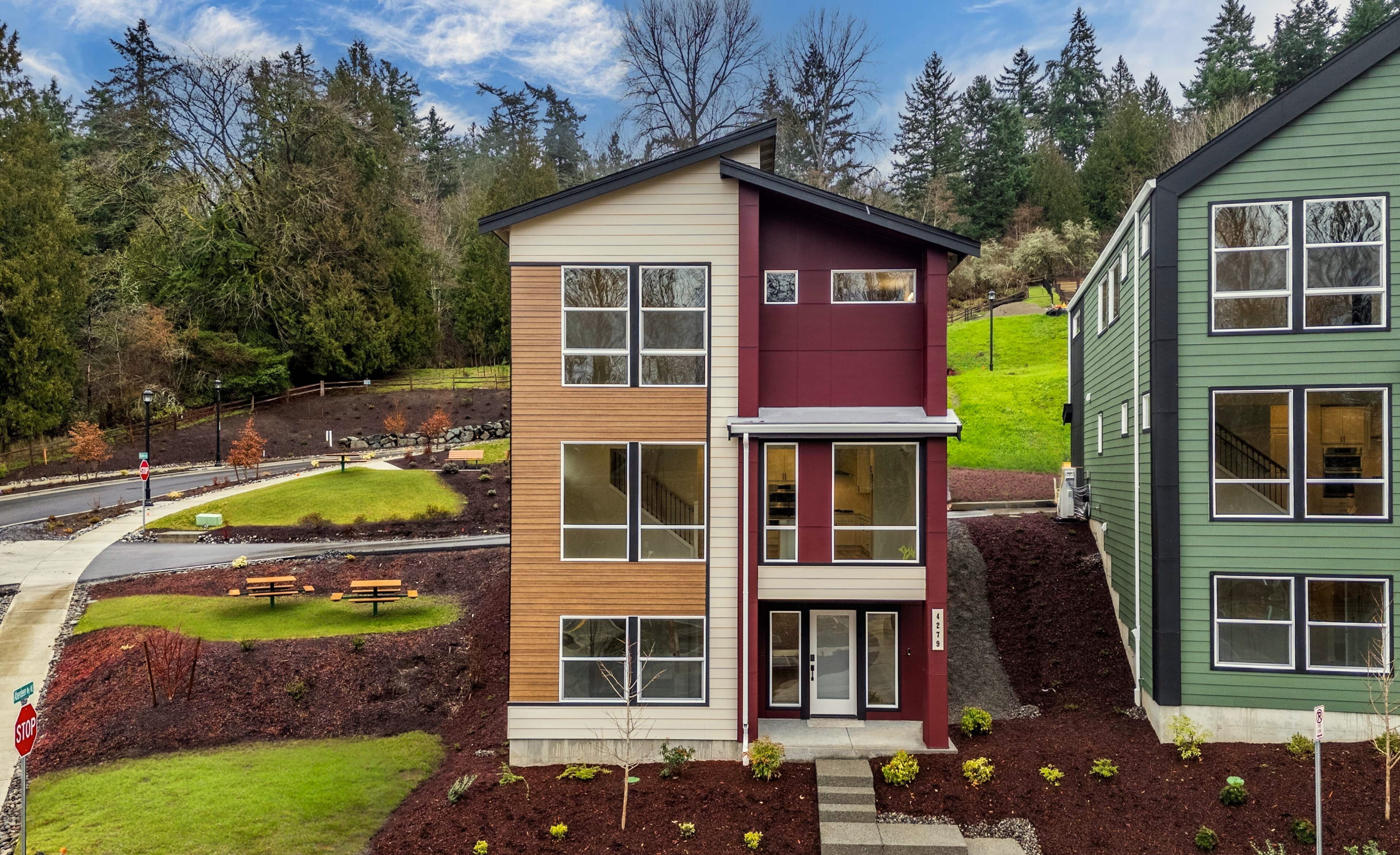 A house with a lawn and trees in the back.
