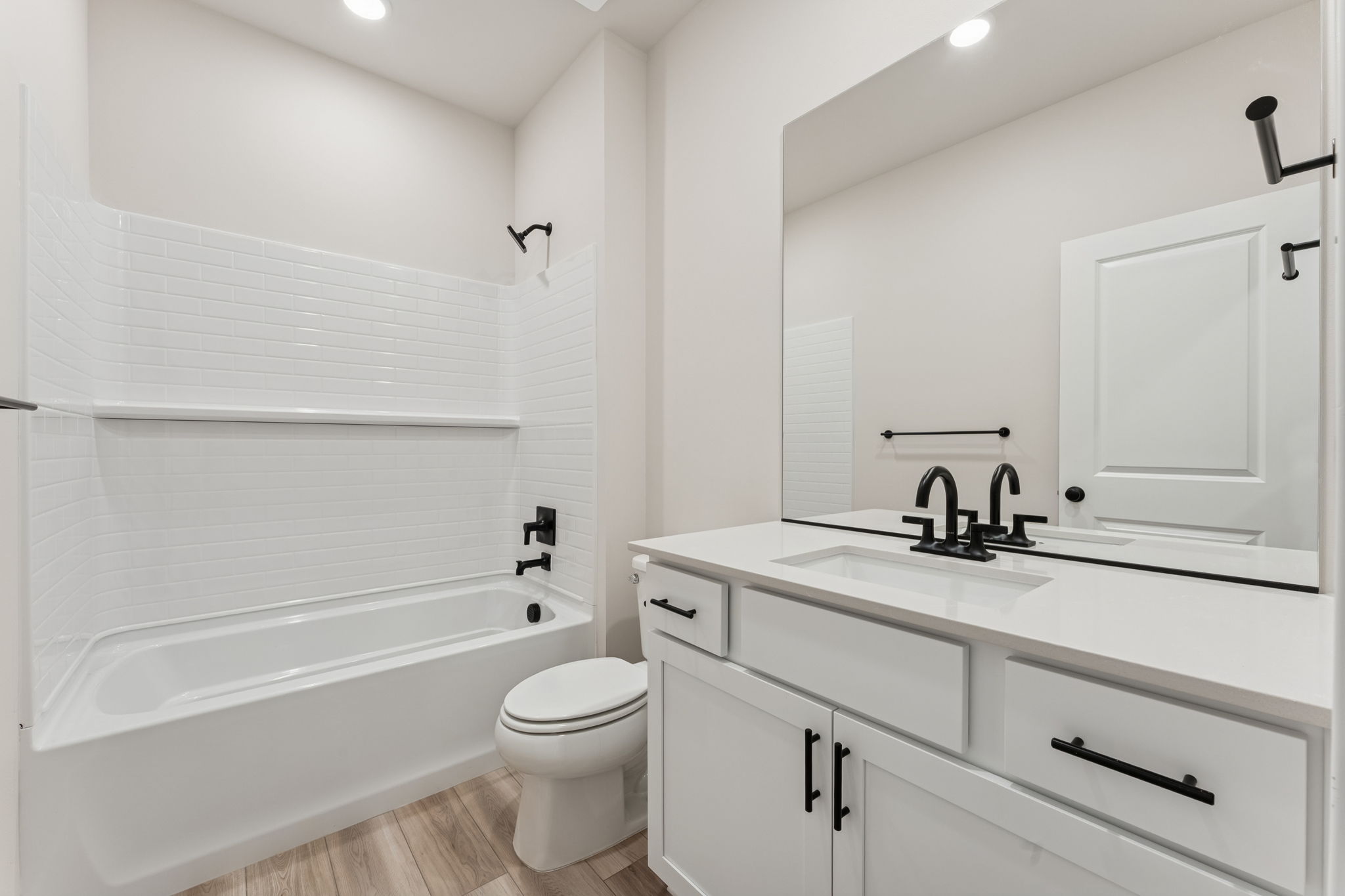 A bathroom with white cabinets.