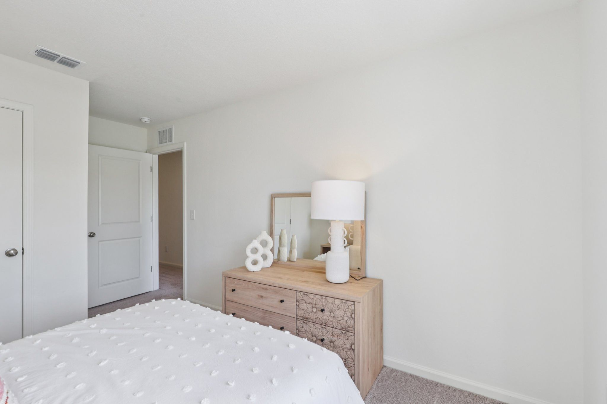 A bedroom with a bed and a lamp.