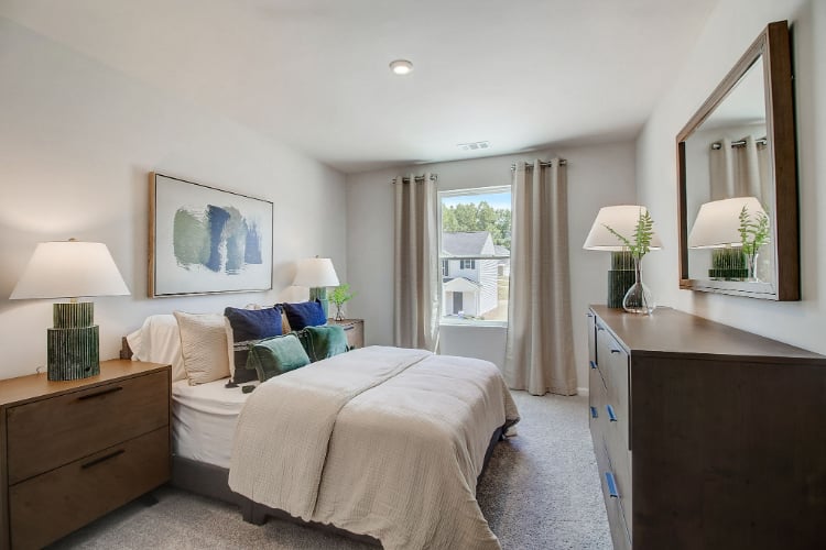 A bedroom with a large mirror.