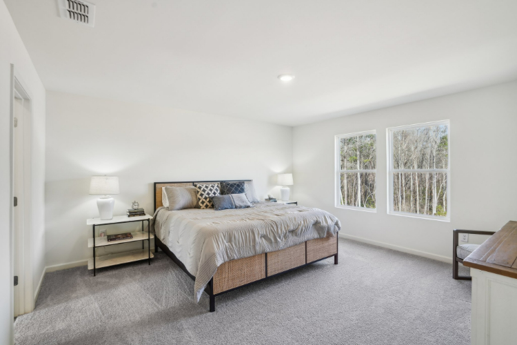 A bedroom with a bed and lamps.