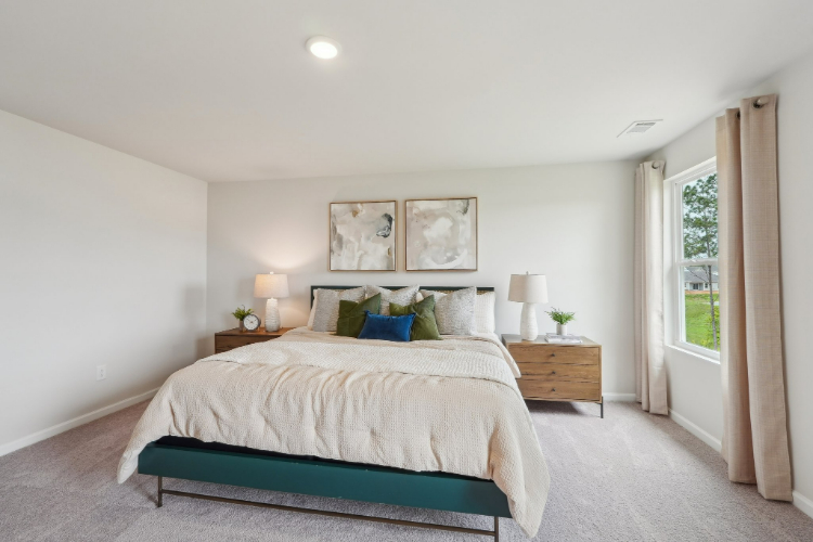 A bedroom with a bed and lamps.