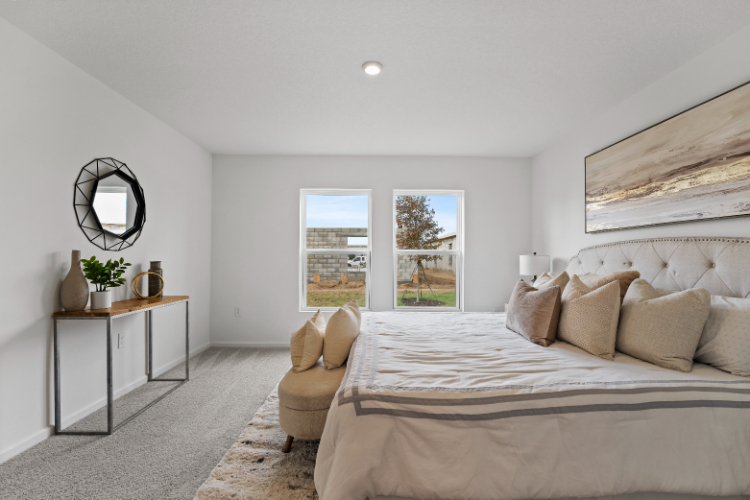 A bedroom with a bed and a chair.