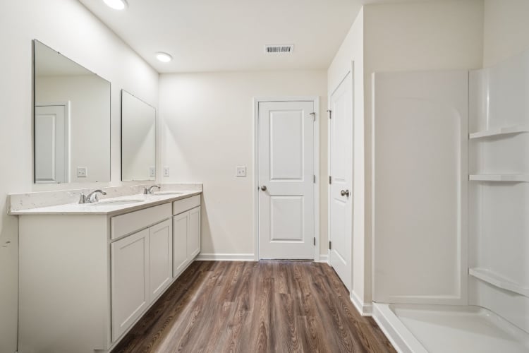 A bathroom with white cabinets.