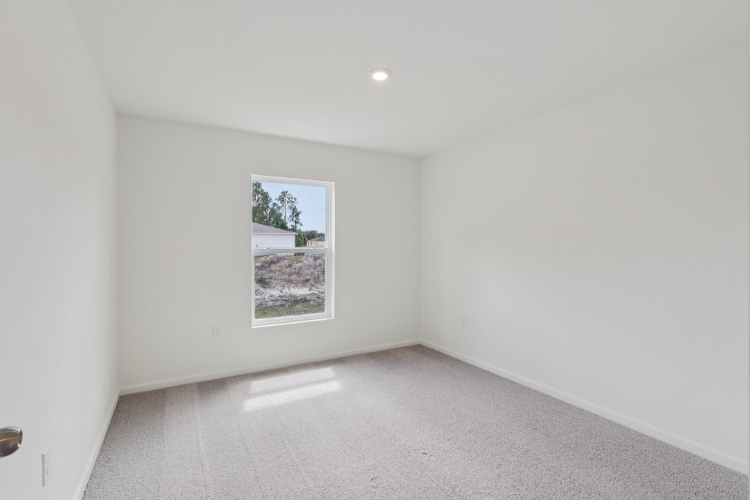 A room with a window and a white wall.