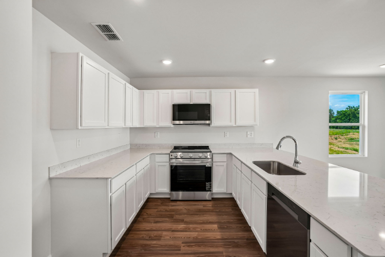 A kitchen with white cabinets.