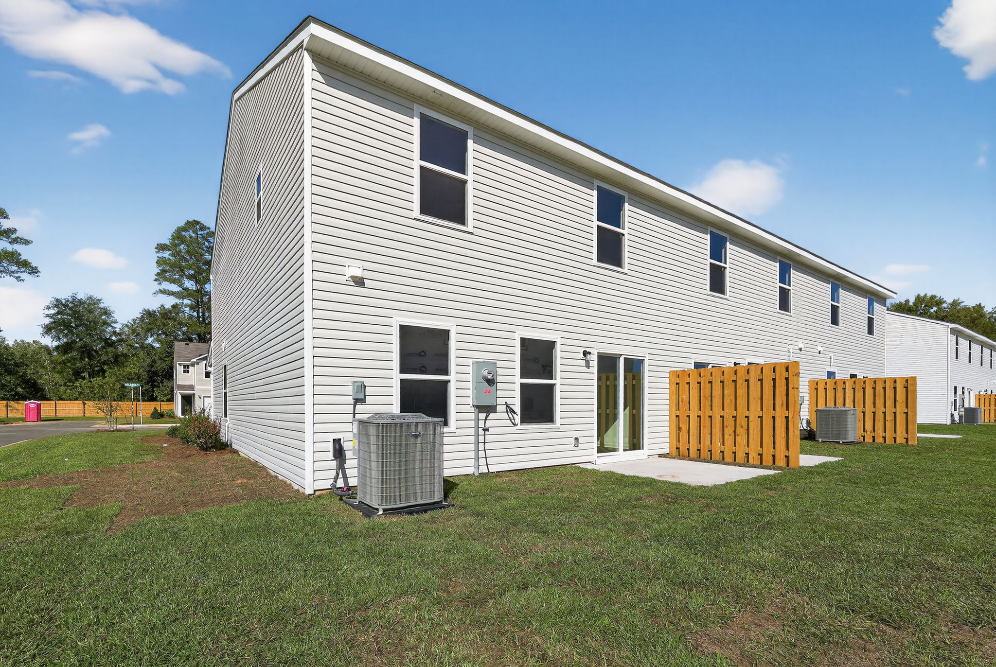 A white building with a fence around it with Rockingham Meeting House in the background.